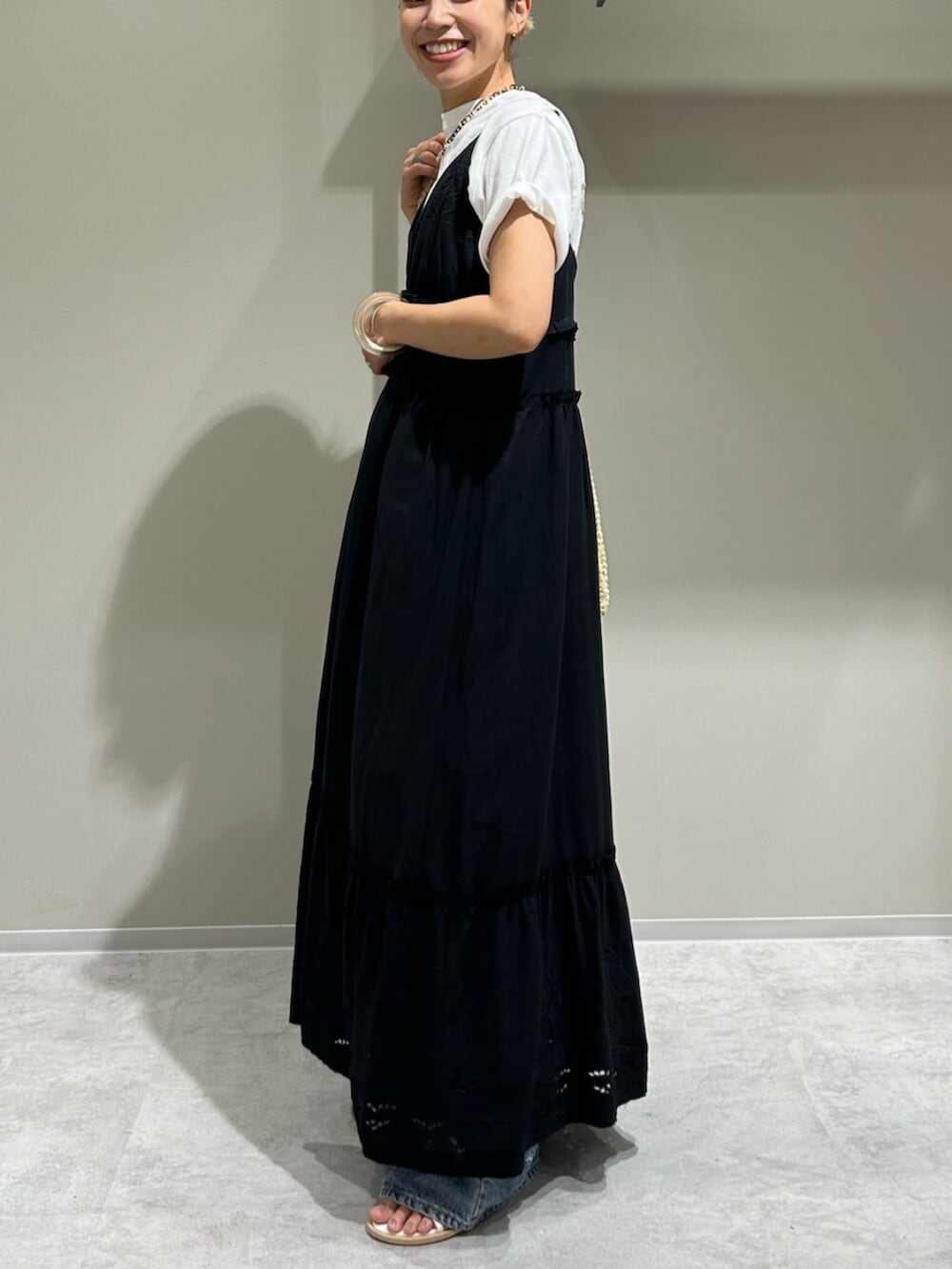 ブルー系のデニムパンツ、ブラック系のワンピース、ホワイト系のTシャツ/カットソーを着用したレディースの夏コーディネートの2枚目の写真