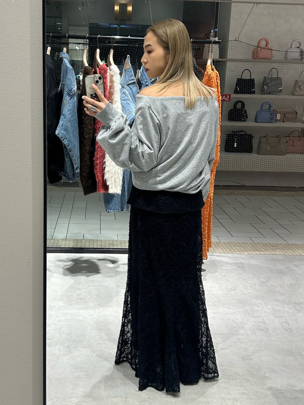 ブラック系のスカート、ホワイト系のTシャツ/カットソー、ベージュ系のローファーを着用したレディースの冬コーディネートの3枚目の写真