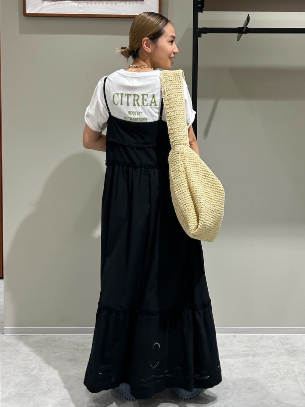 ブルー系のデニムパンツ、ブラック系のワンピース、ホワイト系のTシャツ/カットソーを着用したレディースの夏コーディネートの3枚目の写真