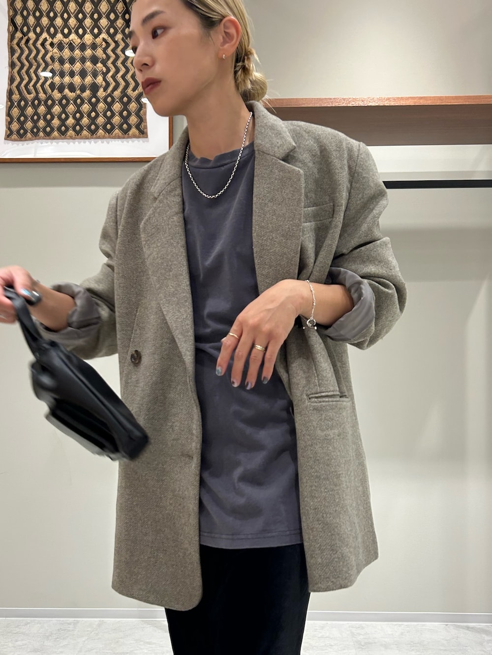 グレー系のテーラードジャケット、ブルー系のTシャツ/カットソー、ブラック系のスカートを着用したレディースの秋コーディネートの4枚目の写真