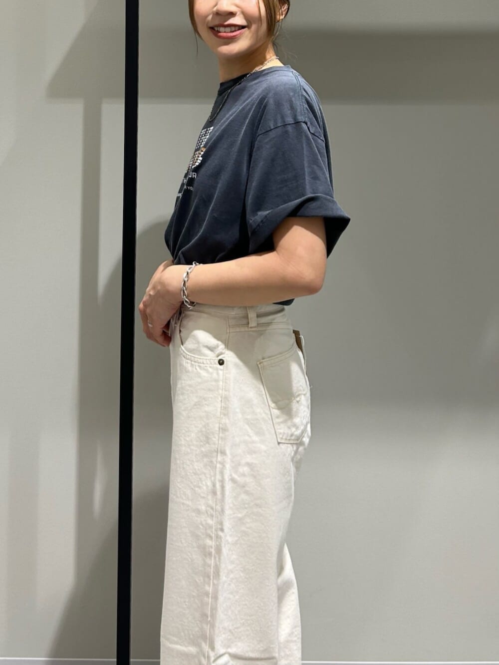 ホワイト系のデニムパンツ、グレー系のTシャツ/カットソー、シルバー系のネックレスを着用したレディースの春コーディネートの7枚目の写真