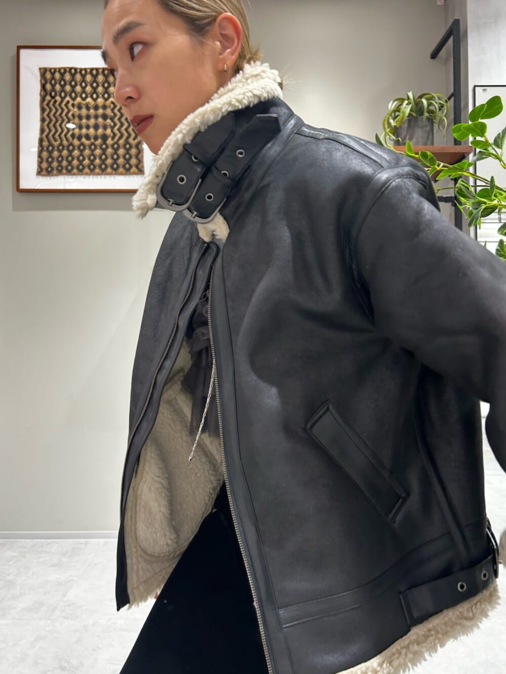 ブラック系のスカート、ブラック系のブルゾン、グレー系のキャミソールを着用したレディースの秋コーディネートの5枚目の写真