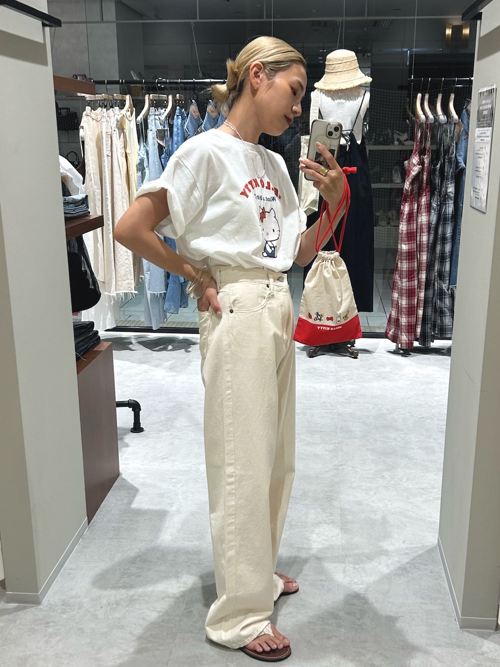 ホワイト系のデニムパンツ、ホワイト系のTシャツ/カットソー、ホワイト系のポーチを着用したレディースの夏コーディネートの2枚目の写真