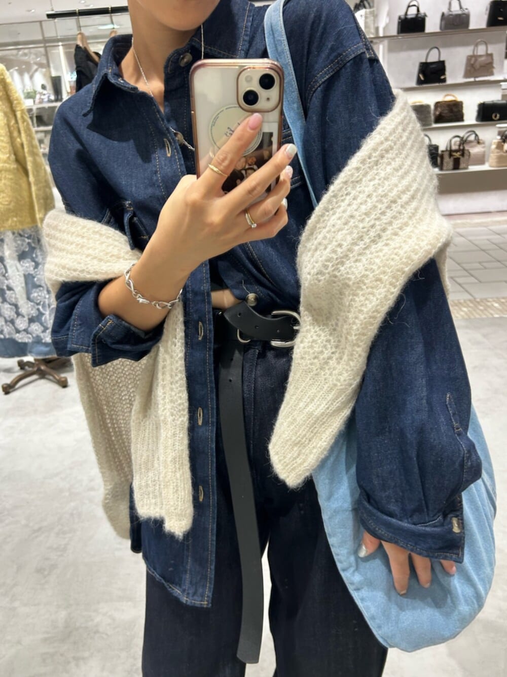 ホワイト系のニット/セーター、ベージュ系のローファー、ブルー系のデニムパンツを着用したレディースの秋コーディネートの6枚目の写真