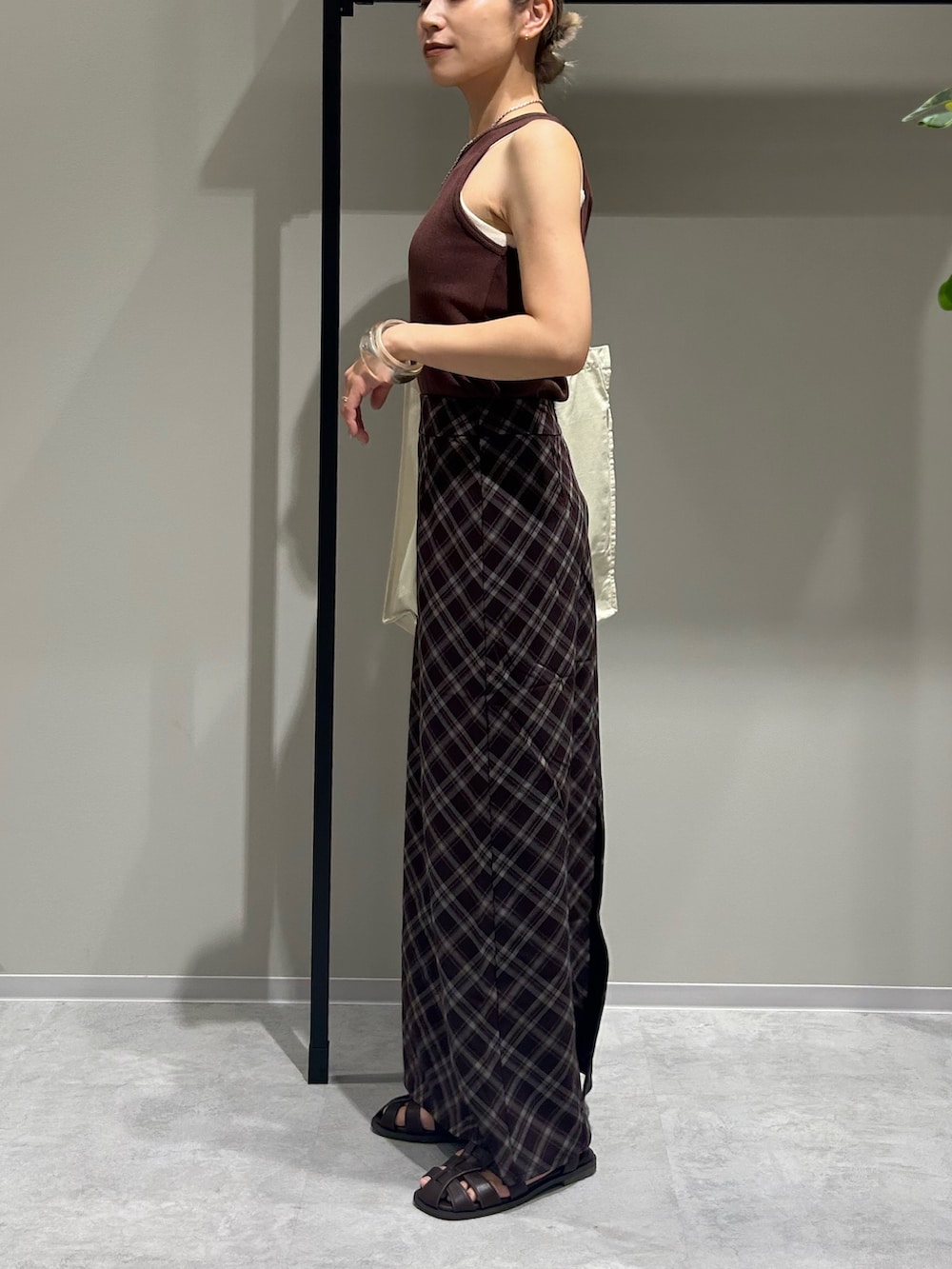 ブラウン系のスカート、ブラウン系のタンクトップ、ホワイト系のトートバッグを着用したレディースの夏コーディネートの5枚目の写真