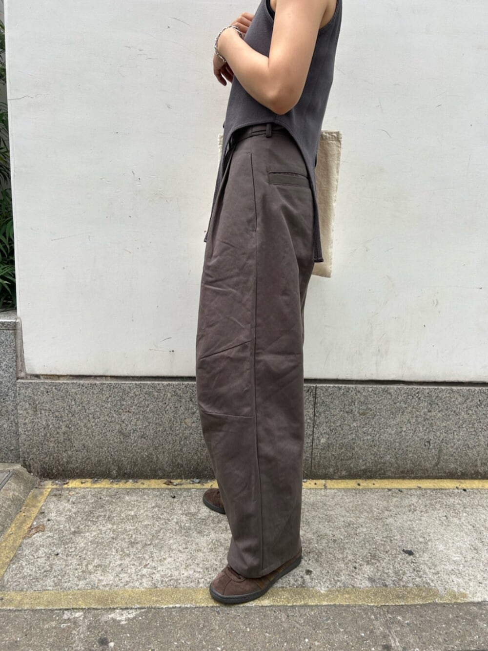 グレー系のチノパンツ、グレー系のタンクトップ、ホワイト系のトートバッグを着用したレディースの春コーディネートの5枚目の写真