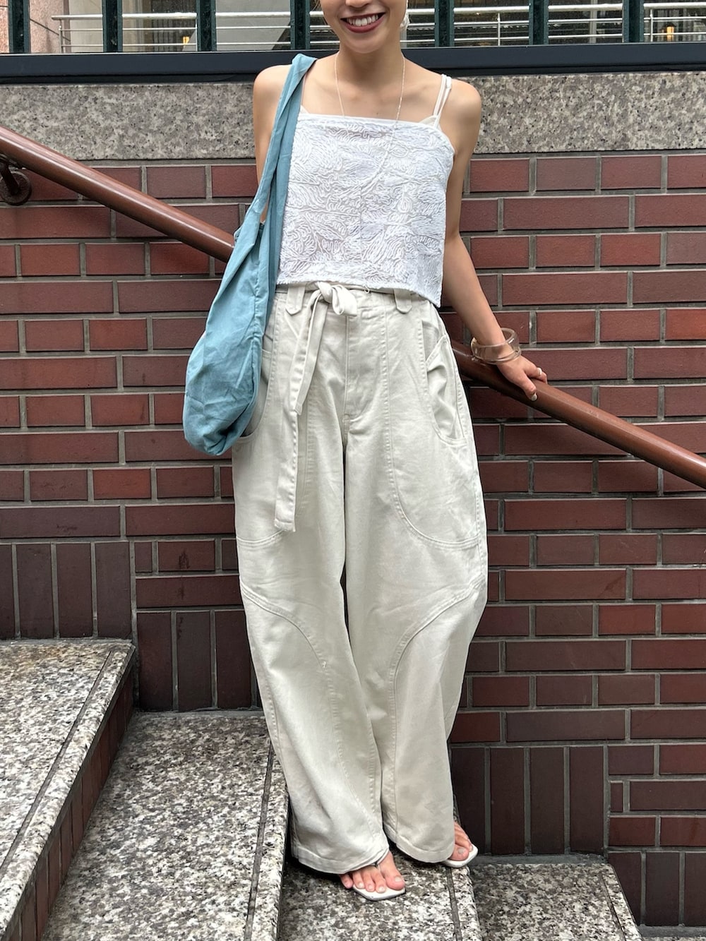 ホワイト系のその他パンツ、ホワイト系のキャミソール、ブルー系のトートバッグを着用したレディースの夏コーディネートの5枚目の写真