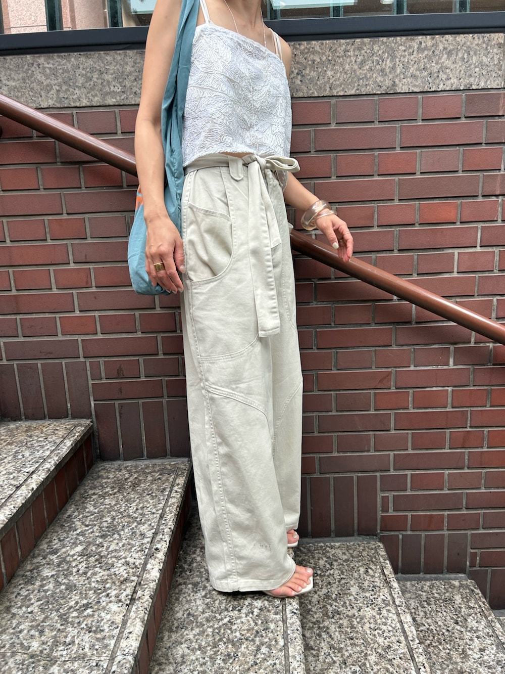 ホワイト系のその他パンツ、ホワイト系のキャミソール、ブルー系のトートバッグを着用したレディースの夏コーディネートの10枚目の写真