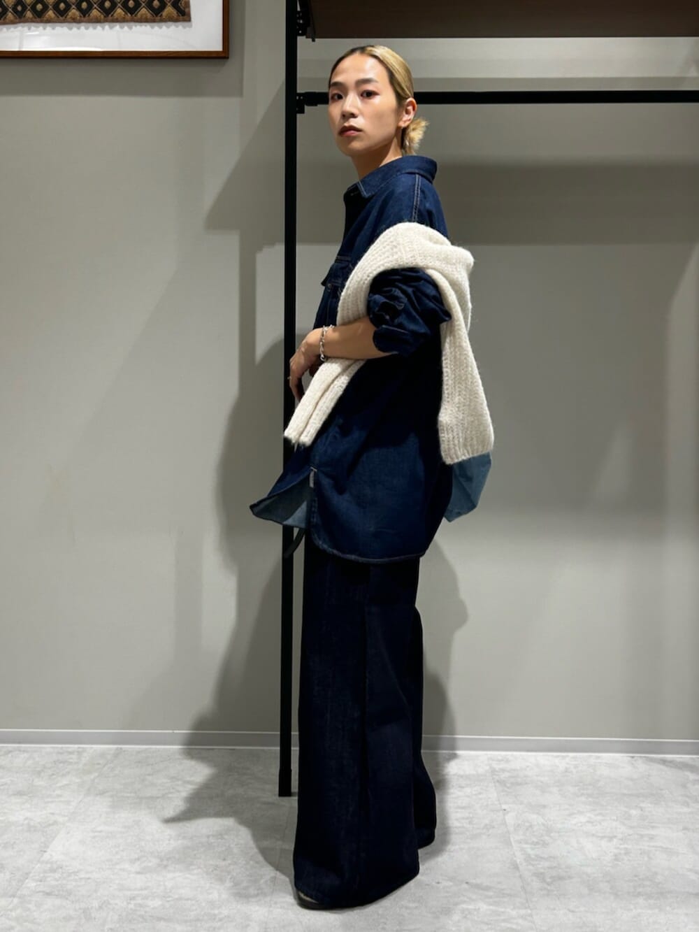 ホワイト系のニット/セーター、ベージュ系のローファー、ブルー系のデニムパンツを着用したレディースの秋コーディネートの2枚目の写真