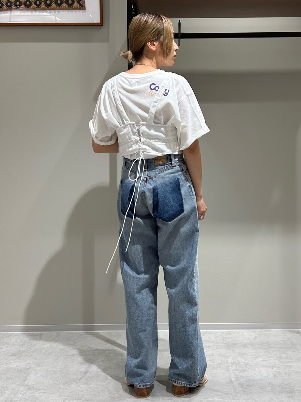 ブルー系のデニムパンツ、ホワイト系のキャミソール、ホワイト系のTシャツ/カットソーを着用したレディースの春コーディネートの3枚目の写真