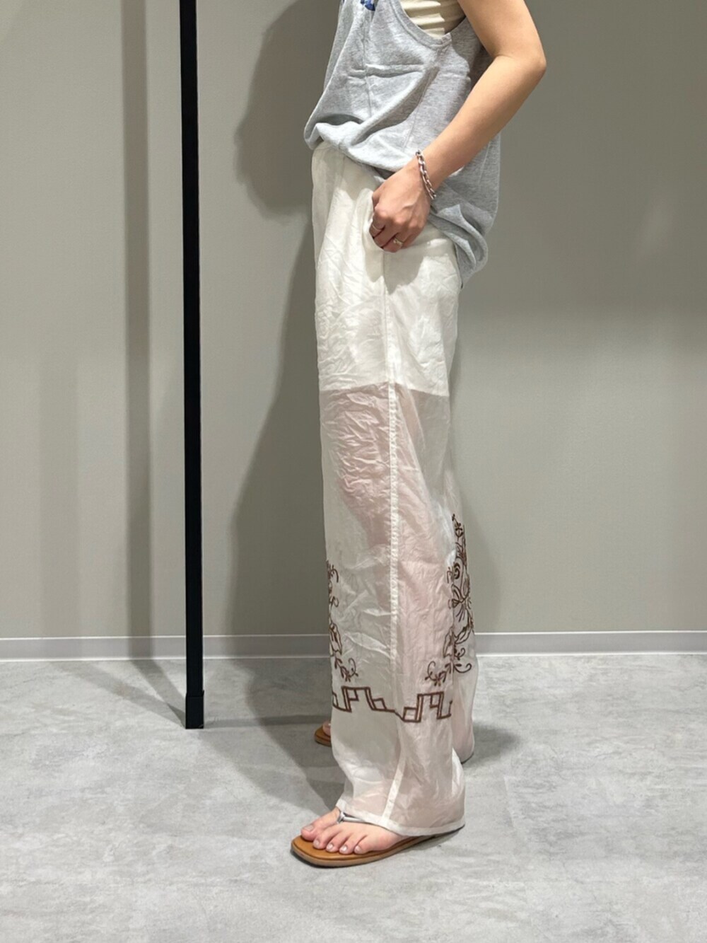 シルバー系のサンダル、ホワイト系のその他パンツ、グレー系のタンクトップを着用したレディースの春コーディネートの7枚目の写真