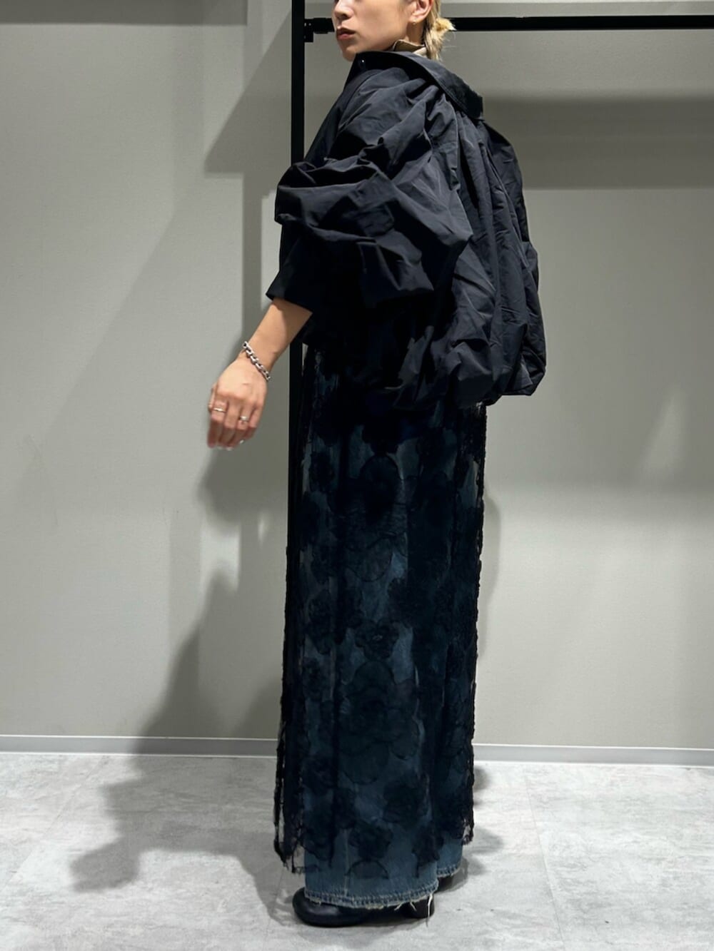 ブルー系のデニムパンツ、ブラック系のブルゾン、ホワイト系のTシャツ/カットソーを着用したレディースの秋コーディネートの2枚目の写真