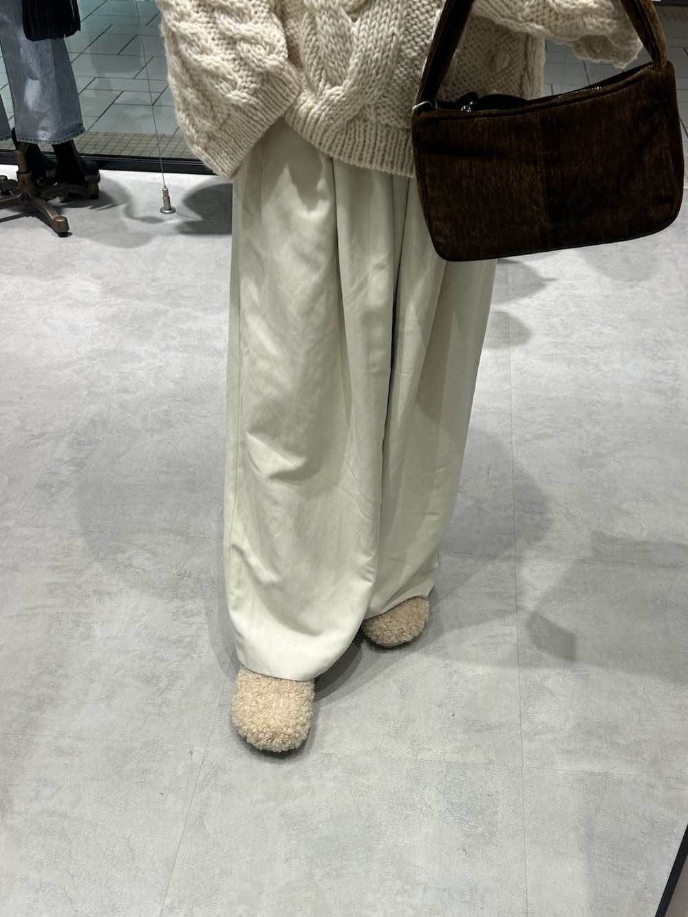 ホワイト系のニット/セーター、ホワイト系のその他パンツ、ブラウン系のハンドバッグを着用したレディースの冬コーディネートの6枚目の写真