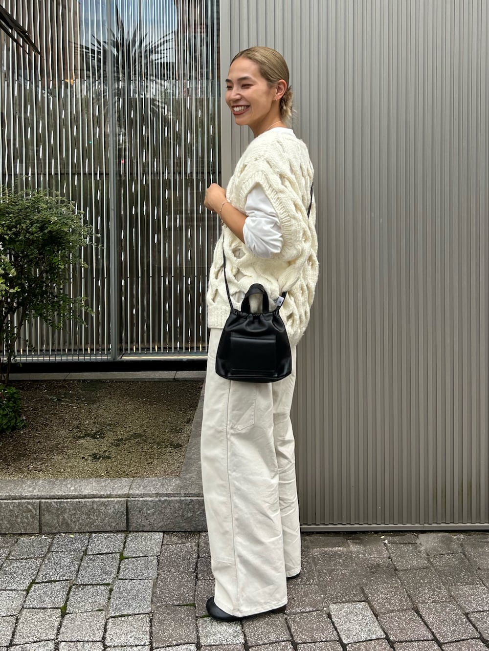ホワイト系のその他パンツ、ホワイト系のニット/セーター、ブラック系のショルダーバッグを着用したレディースの秋コーディネートの2枚目の写真