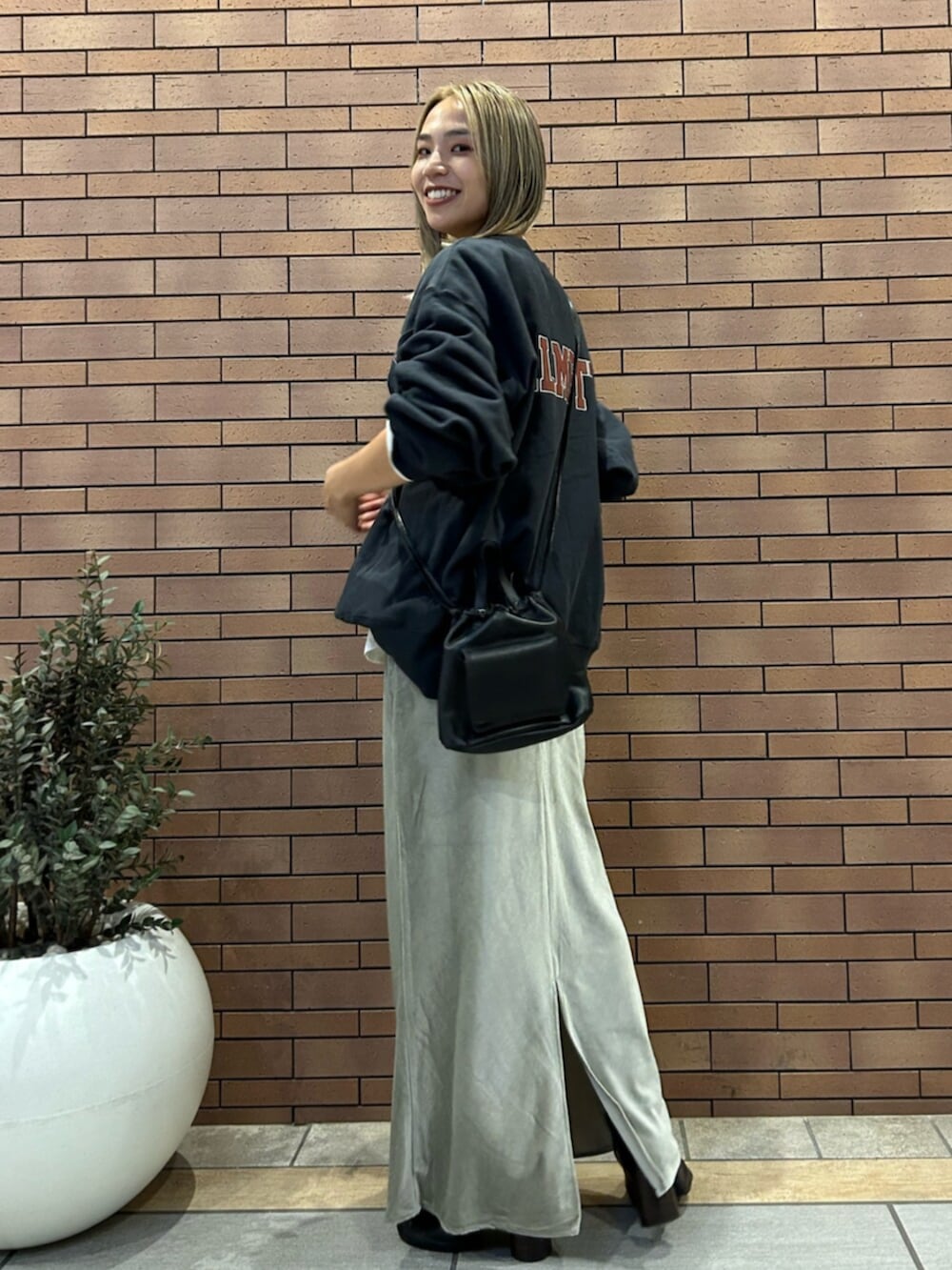 ブラック系のショルダーバッグ、グレー系のスカート、グレー系のスウェットを着用したレディースの秋コーディネートの2枚目の写真