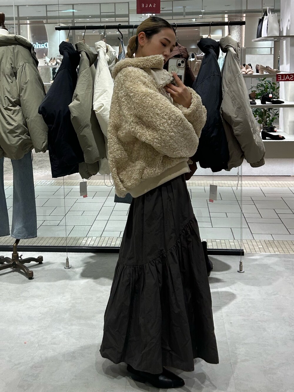 ホワイト系のブルゾン、グレー系のスカート、グレー系のニット/セーターを着用したレディースの冬コーディネートの2枚目の写真