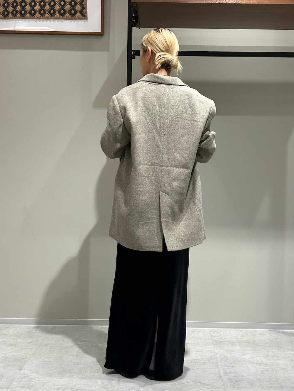 グレー系のテーラードジャケット、ブルー系のTシャツ/カットソー、ブラック系のスカートを着用したレディースの秋コーディネートの3枚目の写真