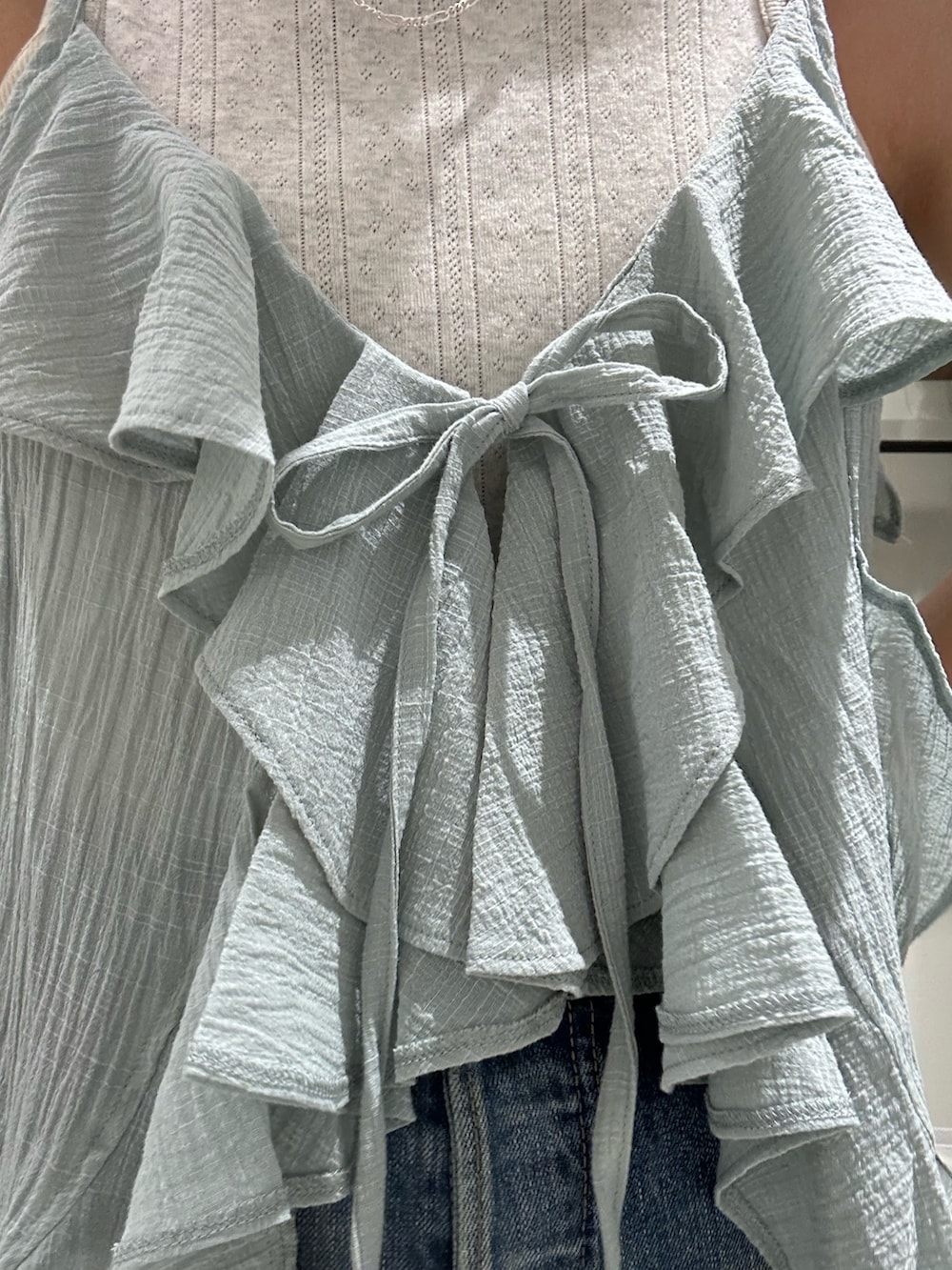 ブルー系のデニムパンツ、グリーン系のキャミソール、グレー系のタンクトップを着用したレディースの夏コーディネートの7枚目の写真