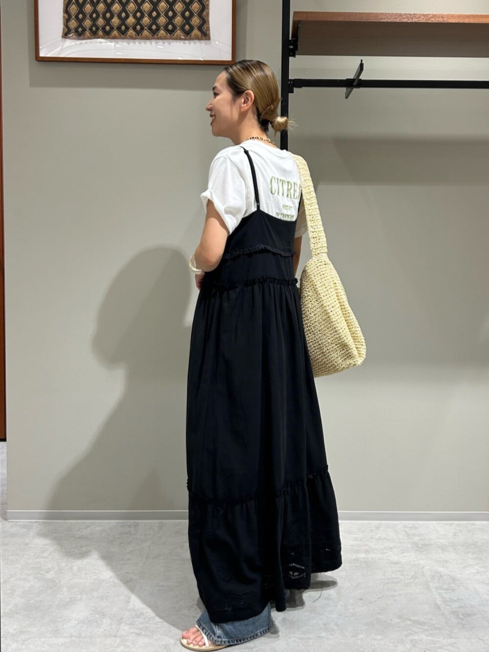 ブルー系のデニムパンツ、ブラック系のワンピース、ホワイト系のTシャツ/カットソーを着用したレディースの夏コーディネートの4枚目の写真