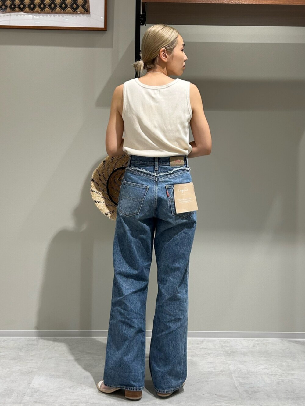 ホワイト系のサンダル、ブルー系のデニムパンツ、ホワイト系のタンクトップを着用したレディースの夏コーディネートの3枚目の写真