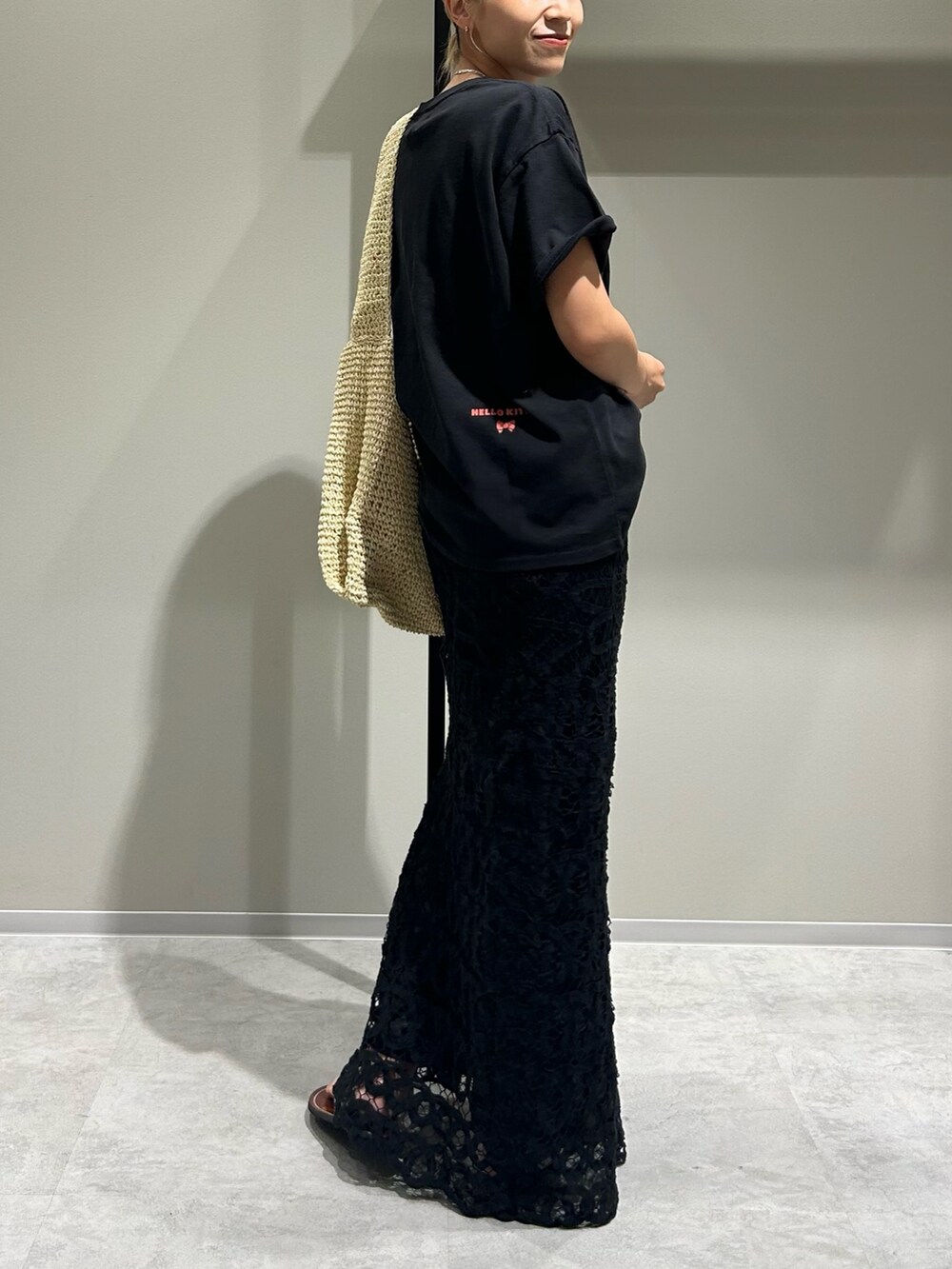 ブラック系のTシャツ/カットソー、ブラック系のスカート、ベージュ系のショルダーバッグを着用したレディースの夏コーディネートの3枚目の写真