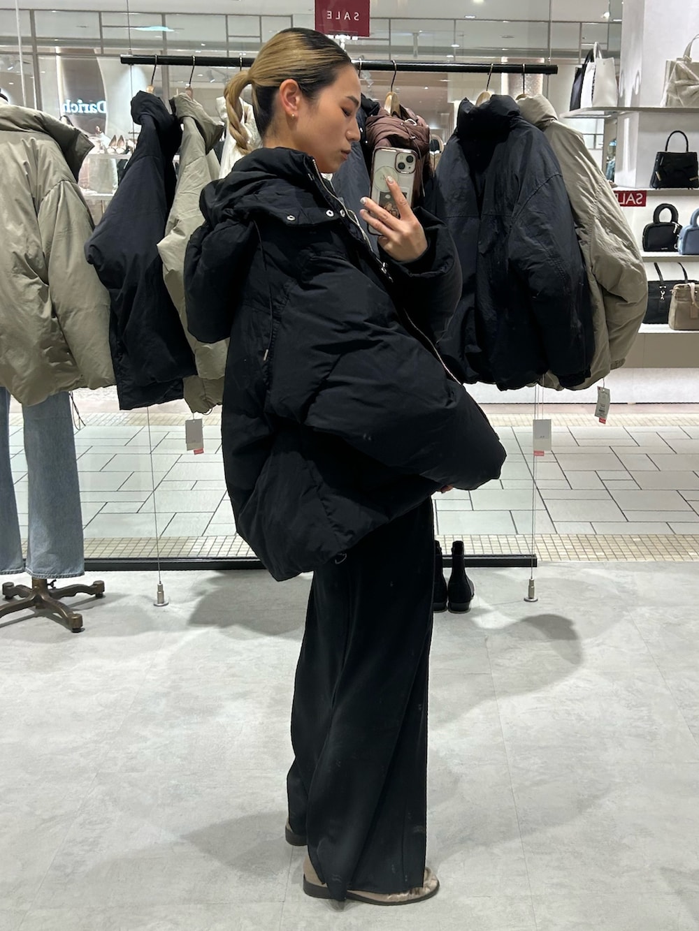 ブラック系のスカート、ブラック系のダウンジャケット/コート、グレー系のニット/セーターを着用したレディースの冬コーディネートの2枚目の写真