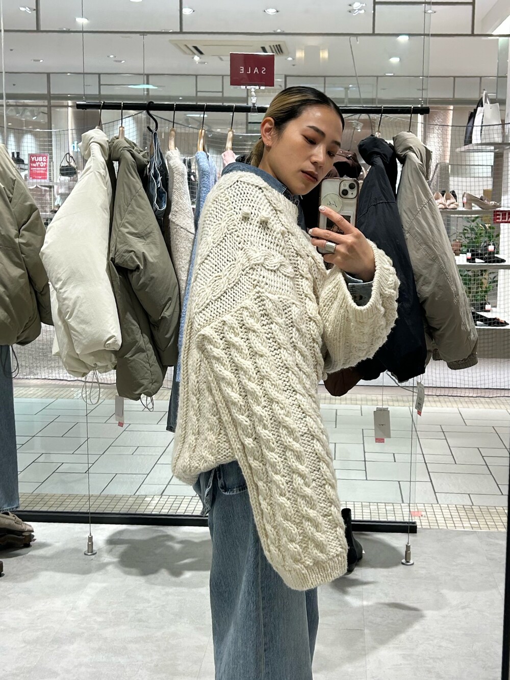 ブルー系のデニムパンツ、ブルー系のシャツ/ブラウス、ホワイト系のニット/セーターを着用したレディースの冬コーディネートの5枚目の写真