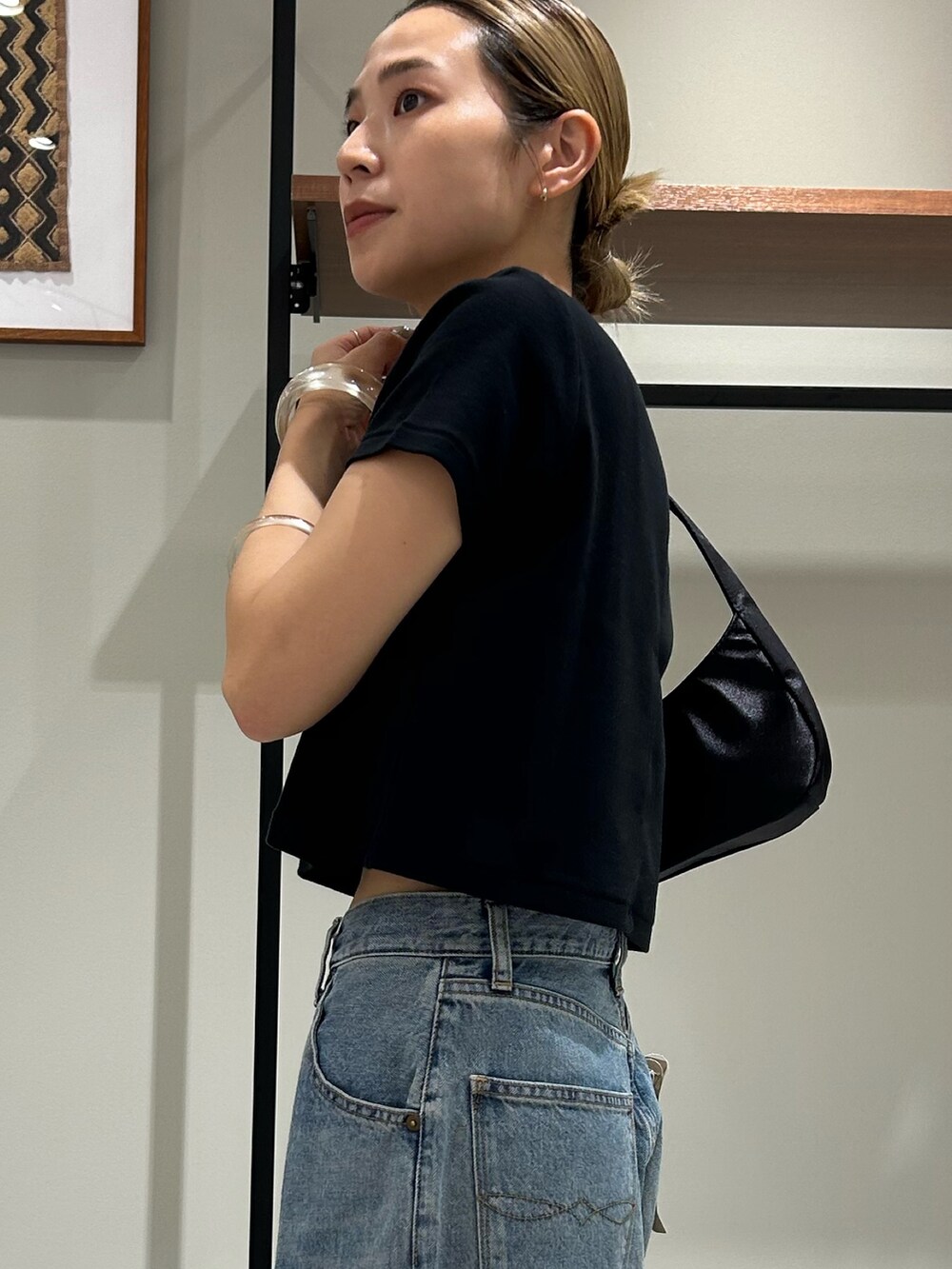 ホワイト系のサンダル、ブラック系のTシャツ/カットソー、ブラック系のハンドバッグを着用したレディースの夏コーディネートの5枚目の写真