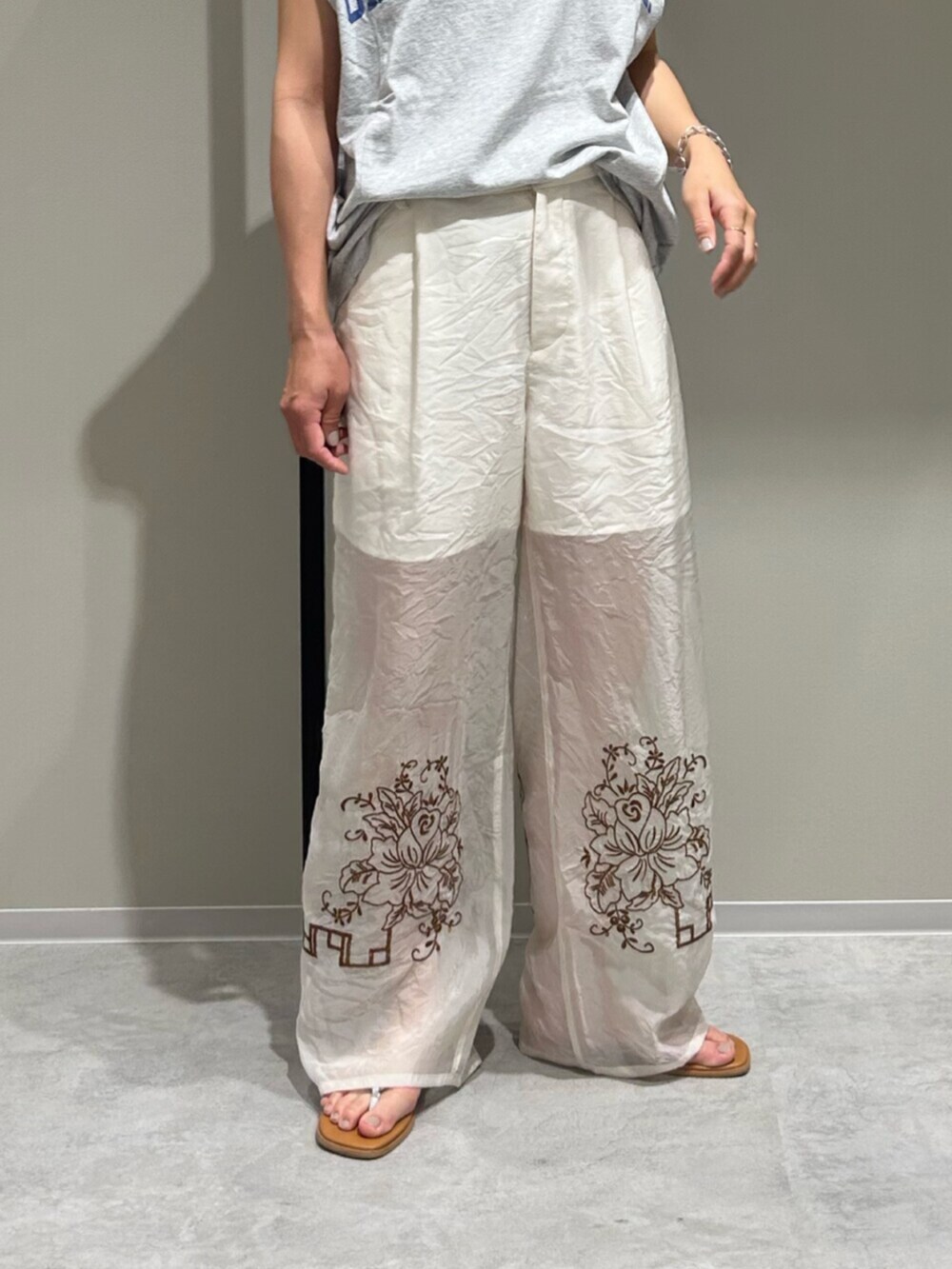 シルバー系のサンダル、ホワイト系のその他パンツ、グレー系のタンクトップを着用したレディースの春コーディネートの6枚目の写真