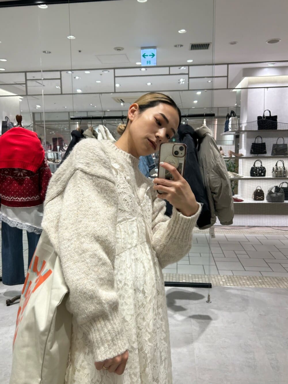 ホワイト系のトートバッグ、ホワイト系のワンピース、ホワイト系のニット/セーターを着用したレディースの冬コーディネートの4枚目の写真