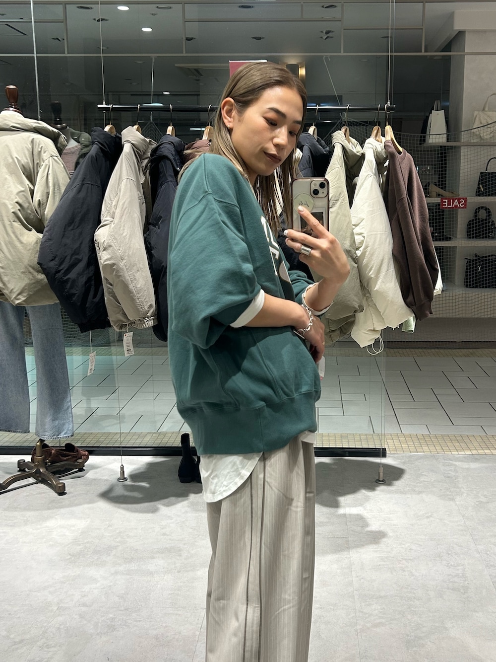 グリーン系のスウェット、ホワイト系のTシャツ/カットソー、ベージュ系のその他パンツを着用したレディースの冬コーディネートの5枚目の写真