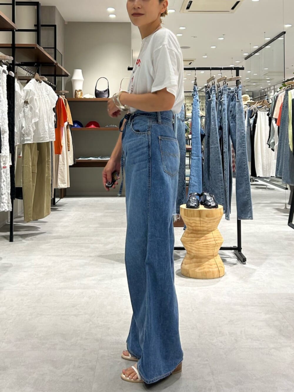 ホワイト系のサンダル、ブルー系のデニムパンツ、ホワイト系のTシャツ/カットソーを着用したレディースの夏コーディネートの2枚目の写真