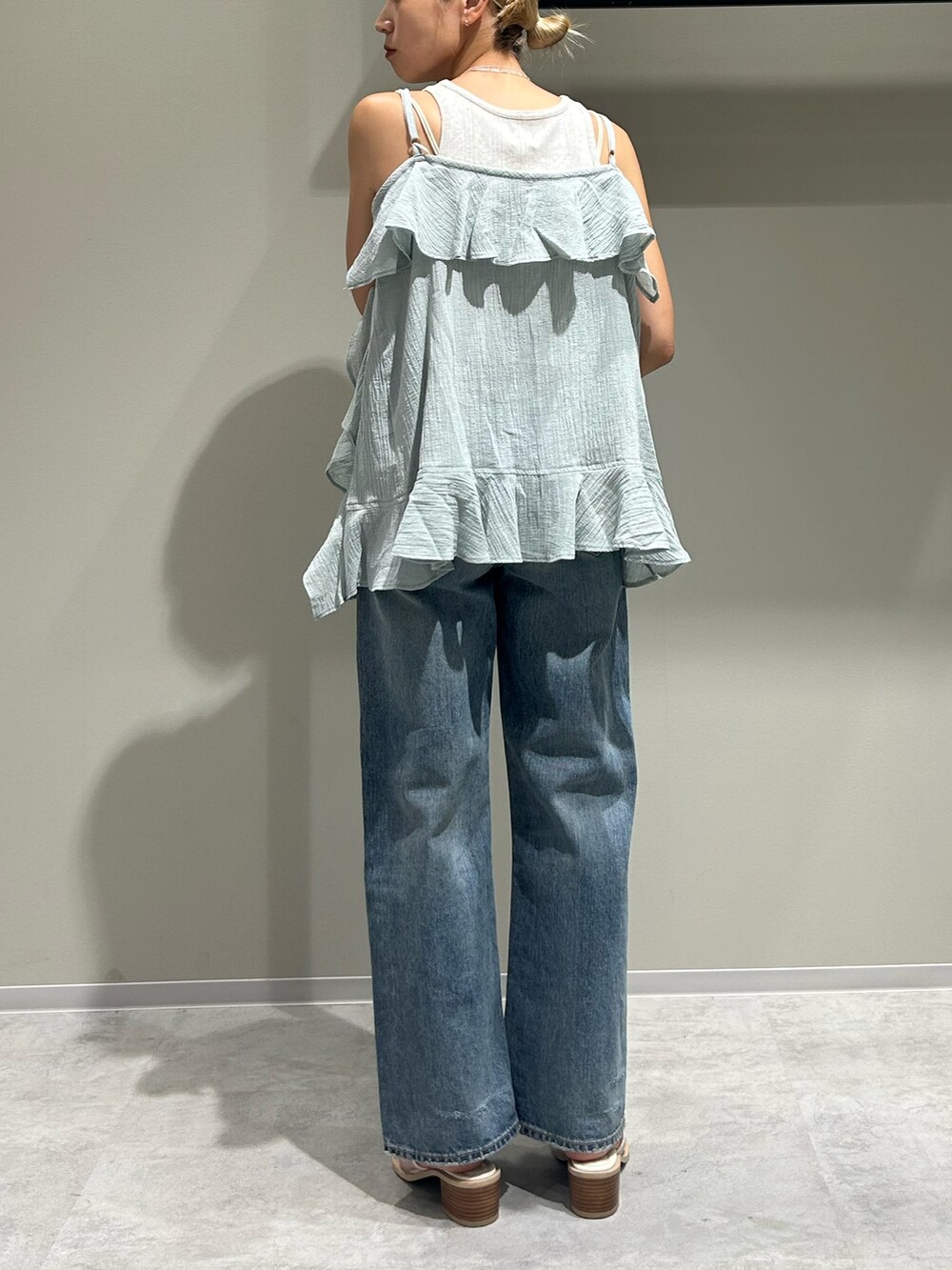 ブルー系のデニムパンツ、グリーン系のキャミソール、グレー系のタンクトップを着用したレディースの夏コーディネートの3枚目の写真