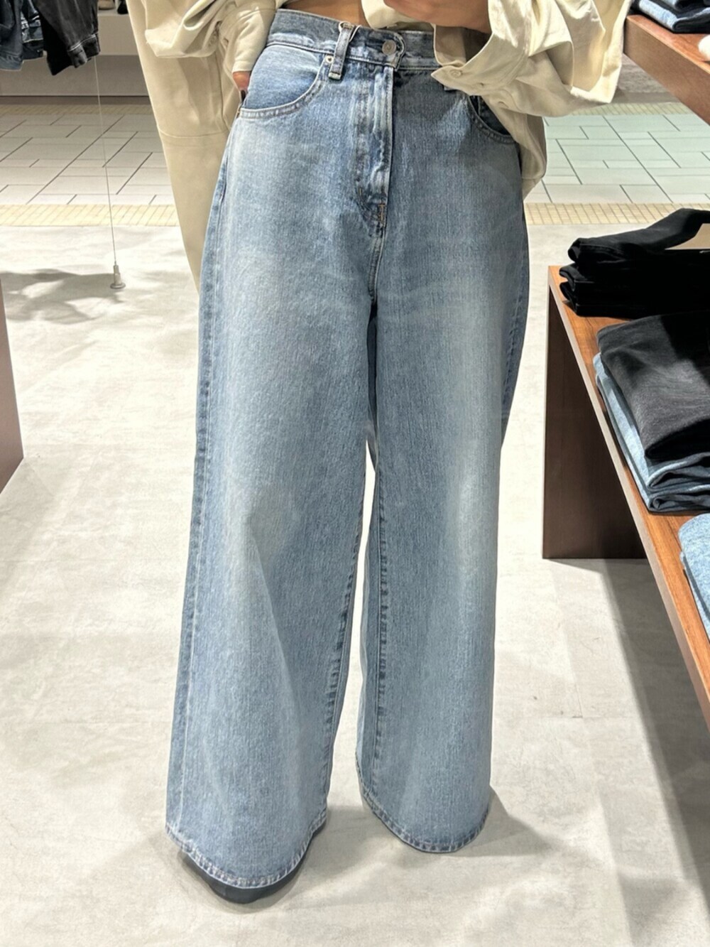 ブラック系のショルダーバッグ、ホワイト系のシャツ/ブラウス、ブルー系のデニムパンツを着用したレディースの秋コーディネートの7枚目の写真