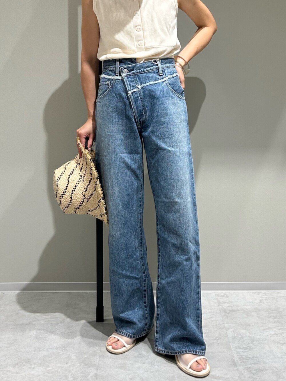 ホワイト系のサンダル、ブルー系のデニムパンツ、ホワイト系のタンクトップを着用したレディースの夏コーディネートの6枚目の写真