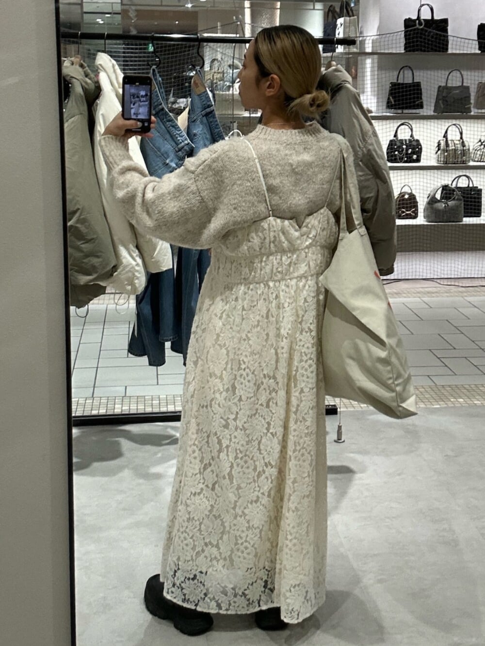 ホワイト系のトートバッグ、ホワイト系のワンピース、ホワイト系のニット/セーターを着用したレディースの冬コーディネートの3枚目の写真