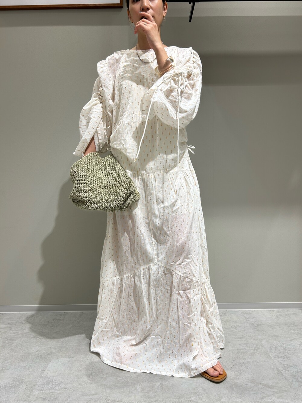ホワイト系のワンピース、グリーン系のショルダーバッグを着用したレディースの夏コーディネートの6枚目の写真