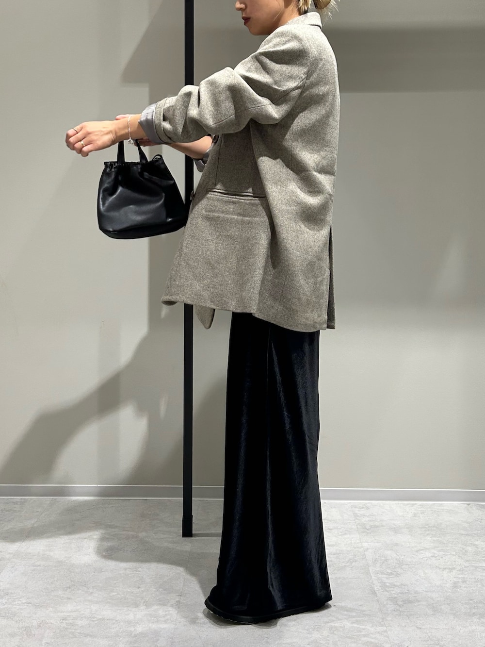 グレー系のテーラードジャケット、ブルー系のTシャツ/カットソー、ブラック系のスカートを着用したレディースの秋コーディネートの2枚目の写真