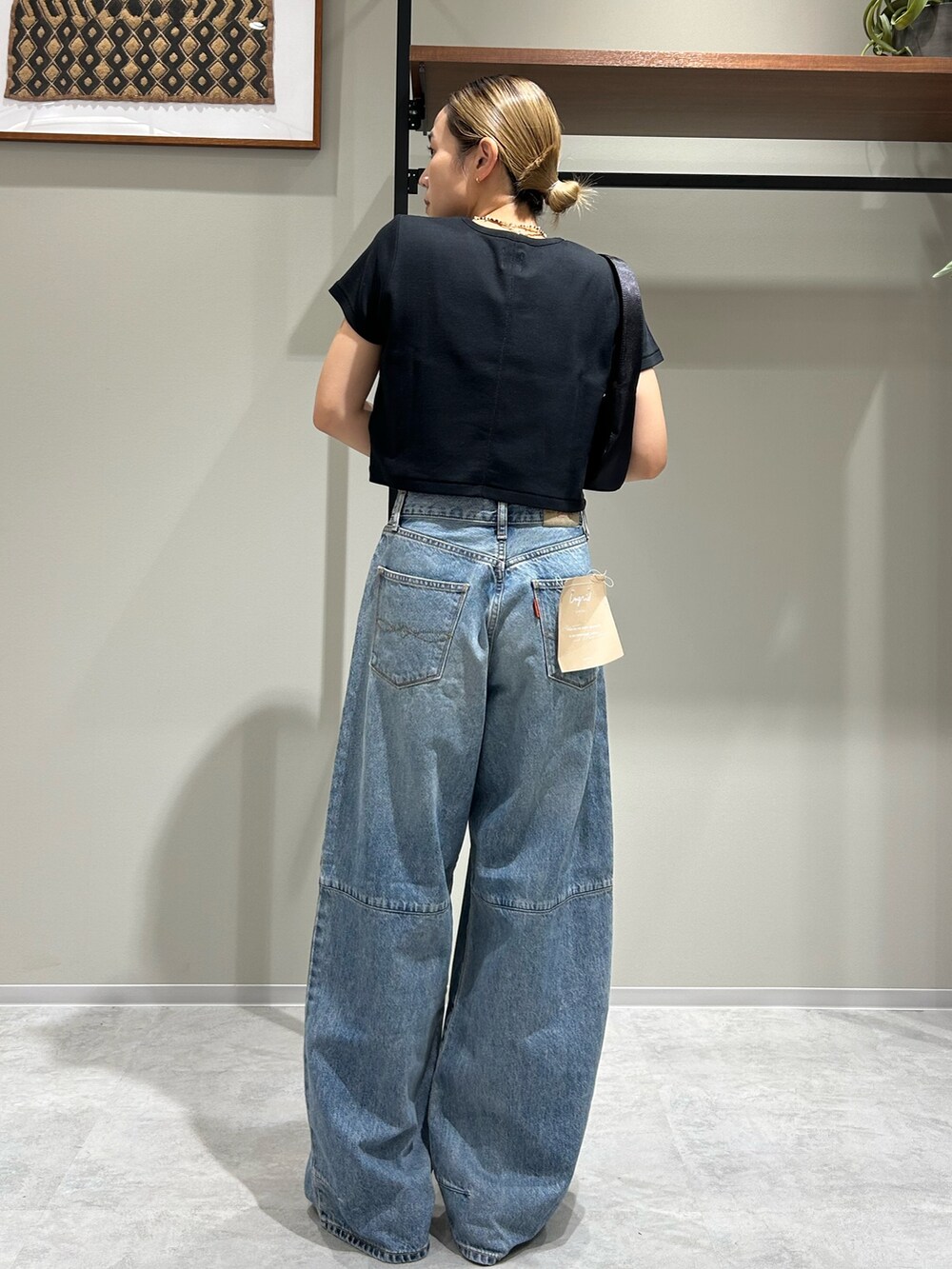 ホワイト系のサンダル、ブラック系のTシャツ/カットソー、ブラック系のハンドバッグを着用したレディースの夏コーディネートの3枚目の写真