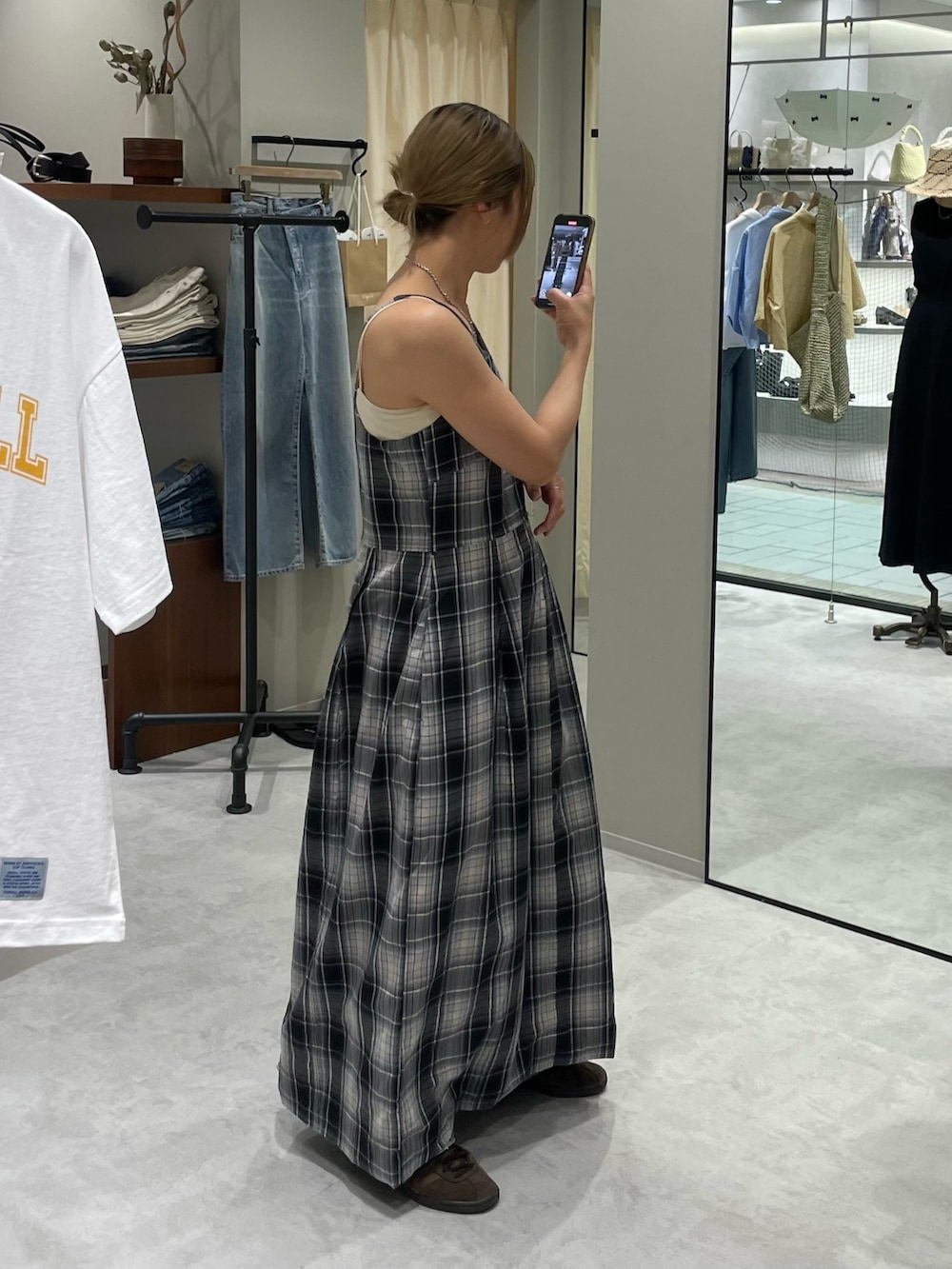 ブルー系のワンピース、ホワイト系のキャミソール、ブルー系のデニムパンツを着用したレディースの夏コーディネートの2枚目の写真