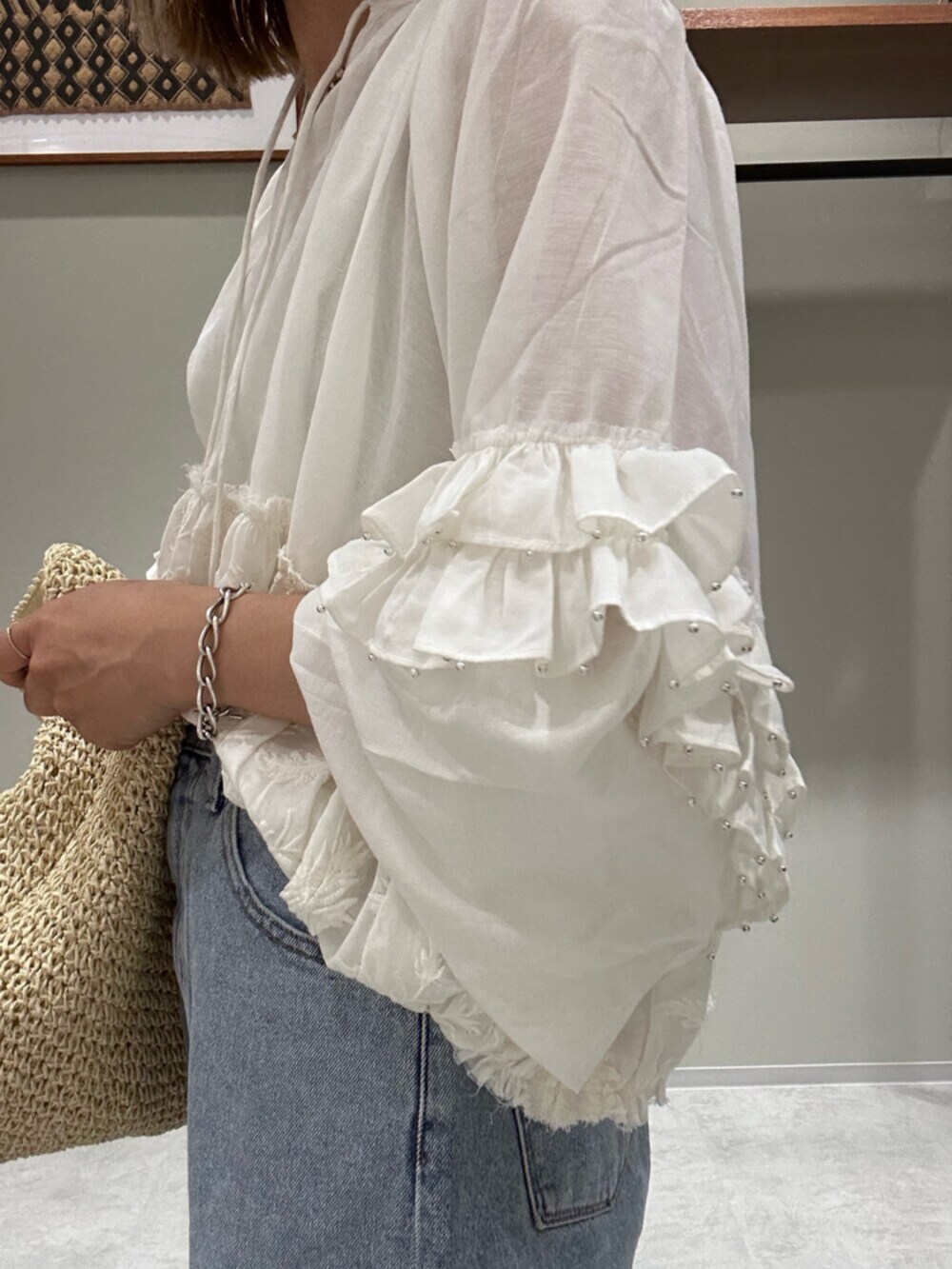 ホワイト系のシャツ/ブラウス、ブルー系のデニムパンツ、シルバー系のサンダルを着用したレディースの春コーディネートの4枚目の写真