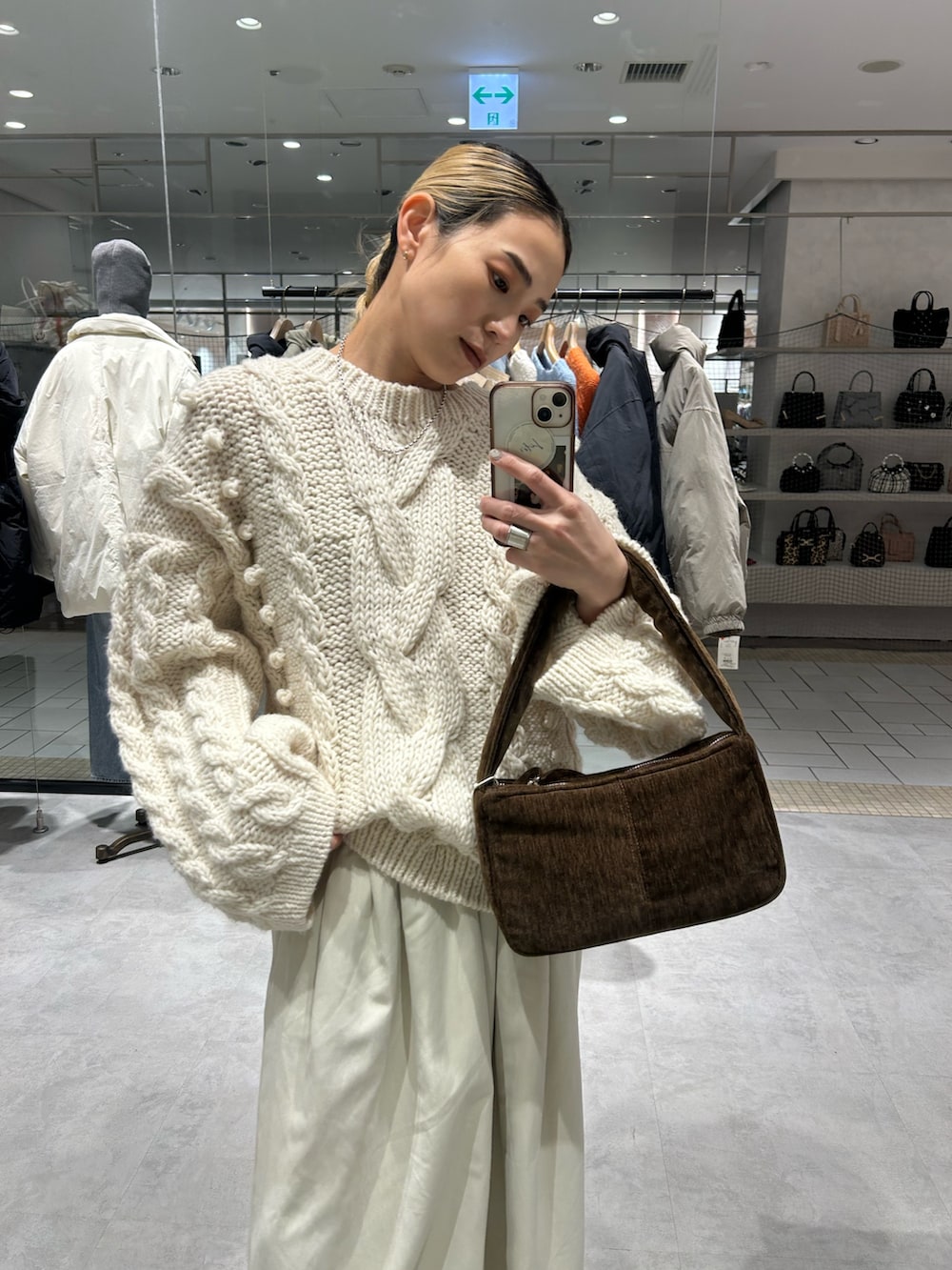 ホワイト系のニット/セーター、ホワイト系のその他パンツ、ブラウン系のハンドバッグを着用したレディースの冬コーディネートの4枚目の写真