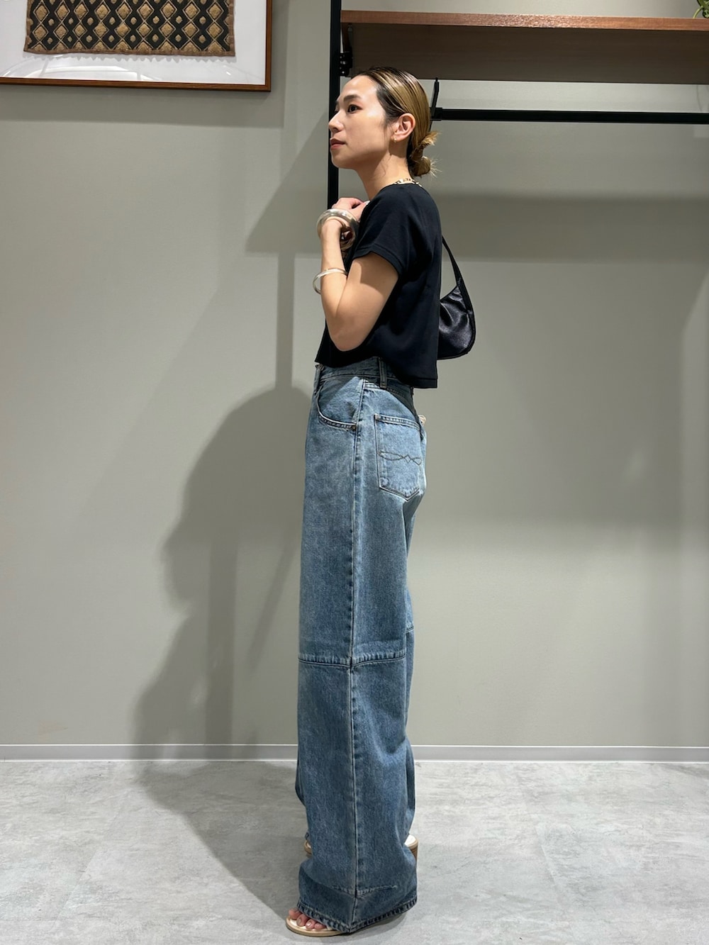 ホワイト系のサンダル、ブラック系のTシャツ/カットソー、ブラック系のハンドバッグを着用したレディースの夏コーディネートの2枚目の写真