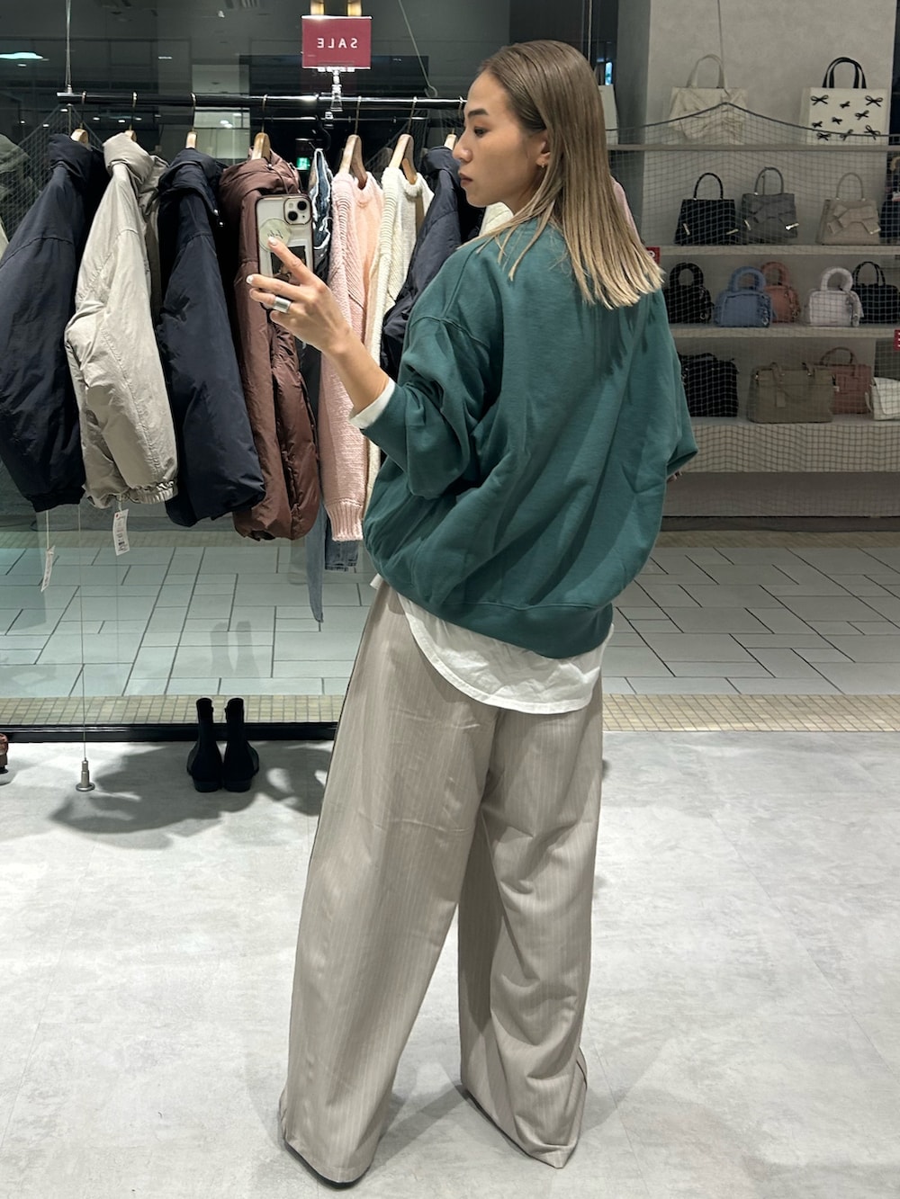 グリーン系のスウェット、ホワイト系のTシャツ/カットソー、ベージュ系のその他パンツを着用したレディースの冬コーディネートの3枚目の写真