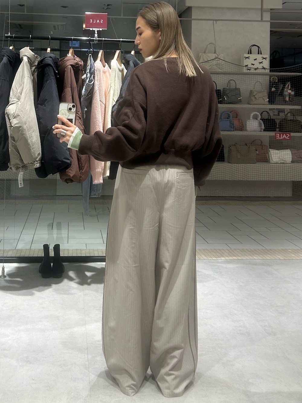 ベージュ系のその他パンツ、ブラウン系のニット/セーター、ホワイト系のTシャツ/カットソーを着用したレディースの冬コーディネートの3枚目の写真