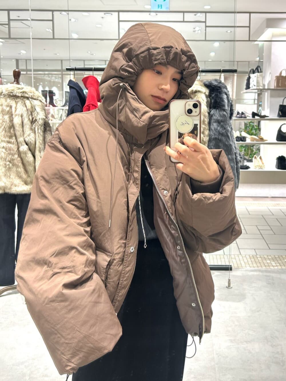 ブラック系のスカート、ベージュ系のローファー、ブラウン系のダウンジャケット/コートを着用したレディースの秋コーディネートの6枚目の写真