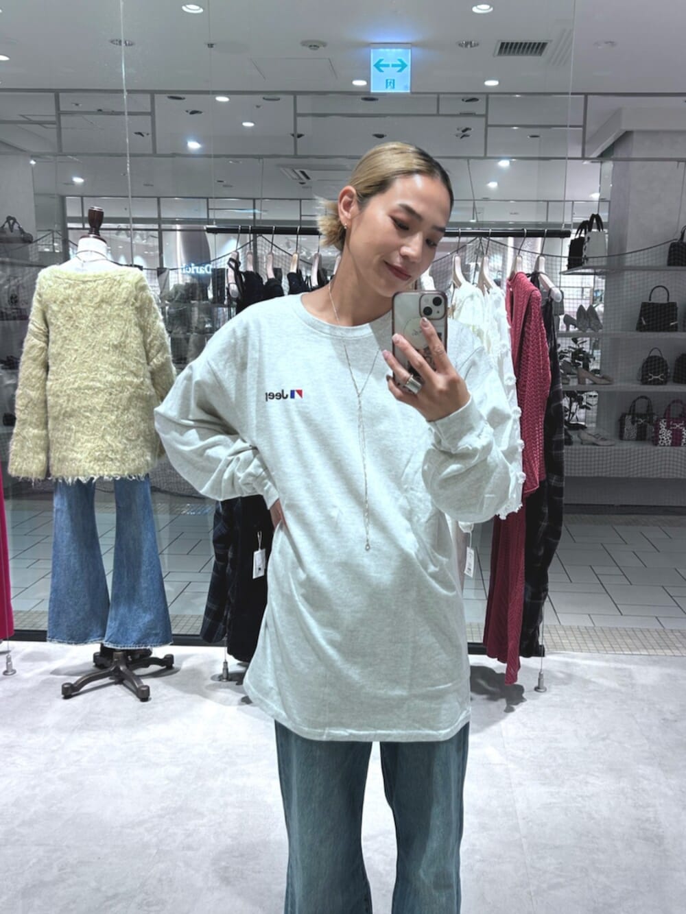 ブルー系のデニムパンツ、グレー系のTシャツ/カットソーを着用したレディースの秋コーディネートの5枚目の写真