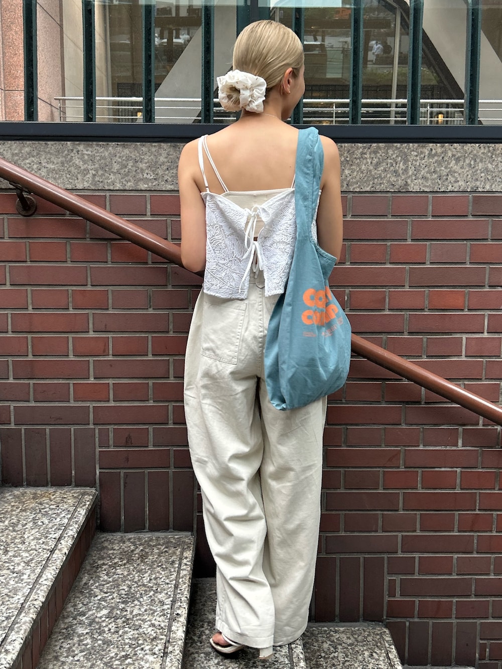 ホワイト系のその他パンツ、ホワイト系のキャミソール、ブルー系のトートバッグを着用したレディースの夏コーディネートの3枚目の写真