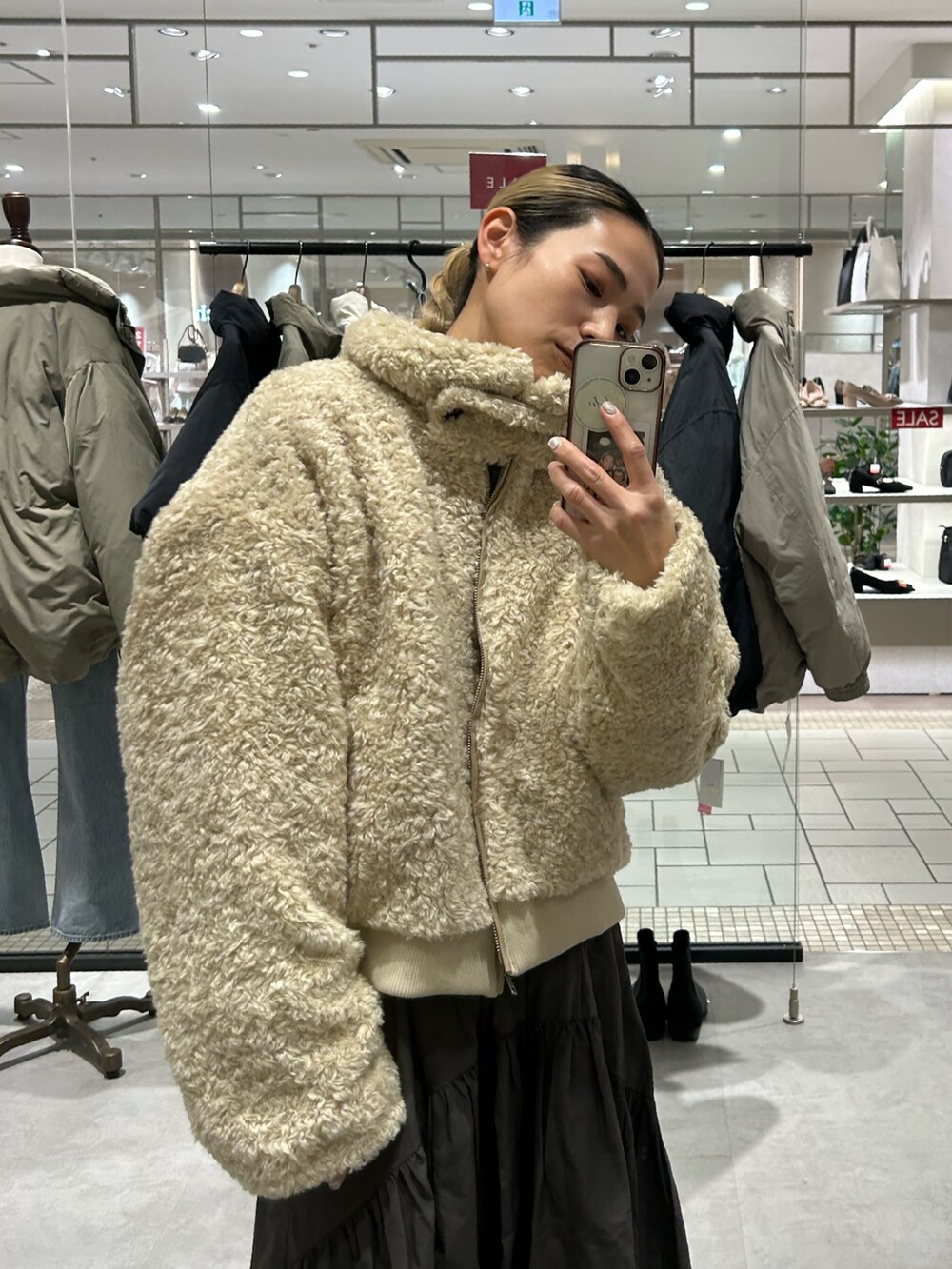 ホワイト系のブルゾン、グレー系のスカート、グレー系のニット/セーターを着用したレディースの冬コーディネートの5枚目の写真