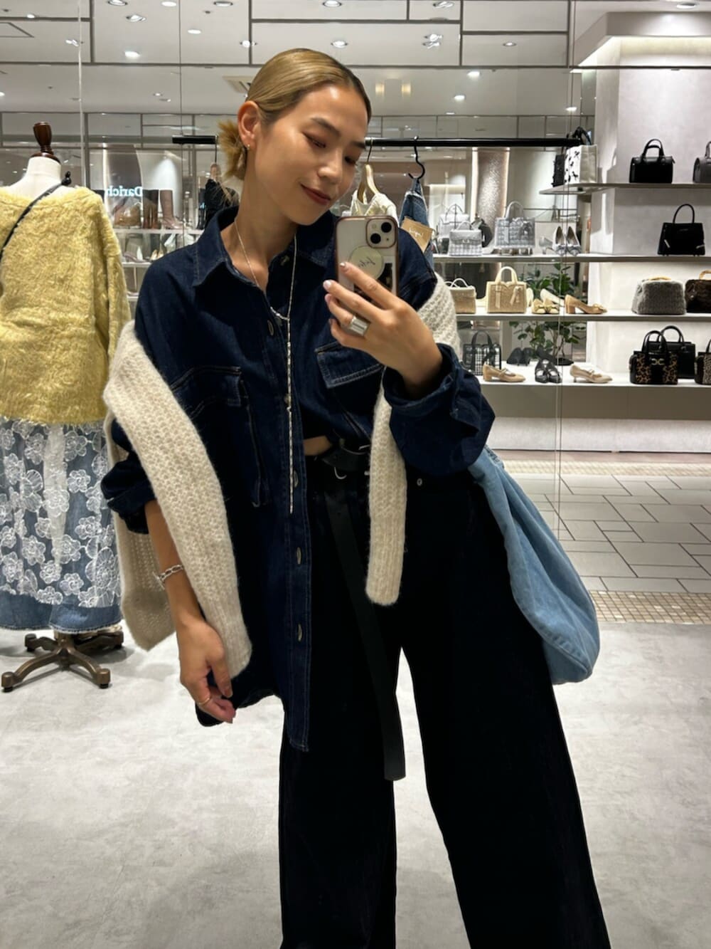 ホワイト系のニット/セーター、ベージュ系のローファー、ブルー系のデニムパンツを着用したレディースの秋コーディネートの5枚目の写真